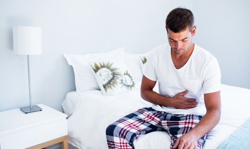Hombre despertando con malestar estomacal