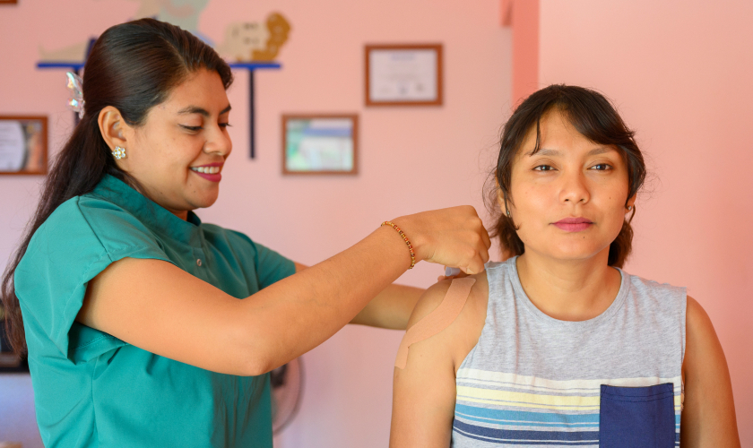 Enfermera colocando parches en la espalda de su paciente