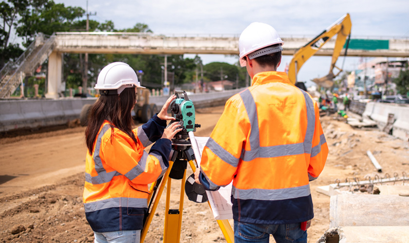 Ingenieros civiles de campo trabajando con un topógrafo
