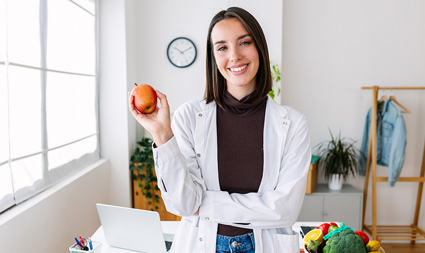 Nutricionista sosteniendo una fruta
