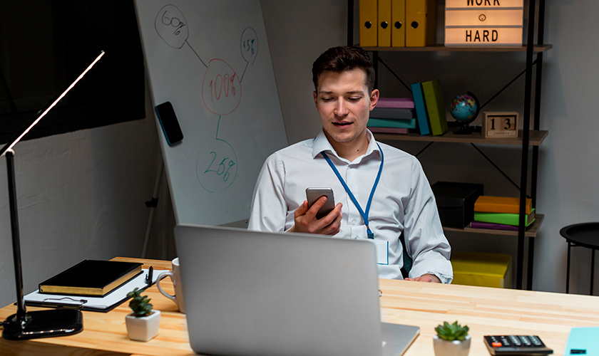 Trabajador revisando su celular en su oficina