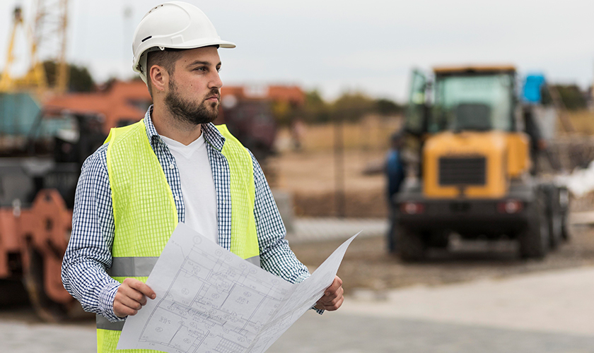 Ingeniero civil con un plano en un campamento minero