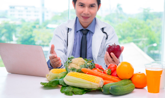 Nutricionista con variedad de vegetales en su escritorio