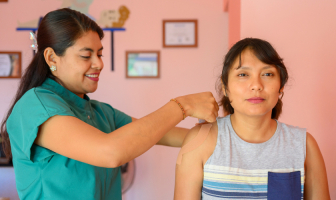 Enfermera colocando parches en la espalda de su paciente