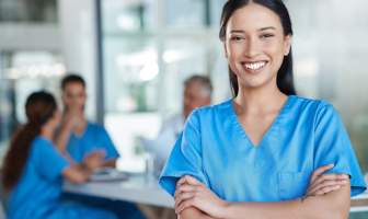 Estudiante de enfermería frente a una conversación entre sus compañeros y un doctor