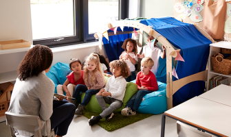 Profesora contándole una historia a sus alumnos de inicial