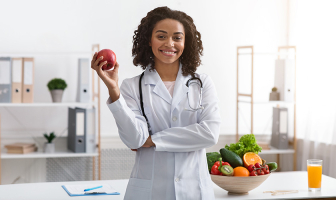 Nutricionista sosteniendo una manzana