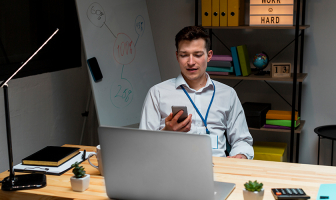Trabajador revisando su celular en su oficina